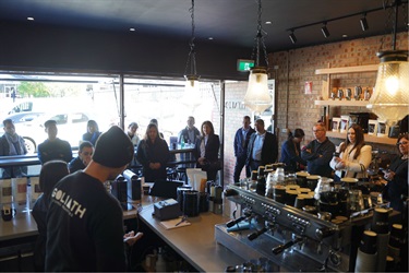 Attendees networking at Goliath Coffee Roaster's business networking event