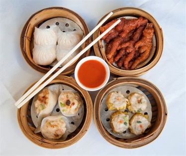 Prawn Dumpling, Chicken Feet, Mix Seafood Dumpling, Dim Sim Pork & Prawn in a bamboo steamer with chili sauce and chopsticks