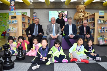 Mayor Frank Carbone, State Librarian John Vallance, Councillor Dai Le and City Manager Alan Young smiling and posing with young children wearing high visibility vests