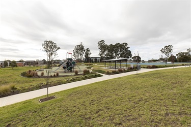 Playground equipment, shaded area with benches and tables, and basketball court