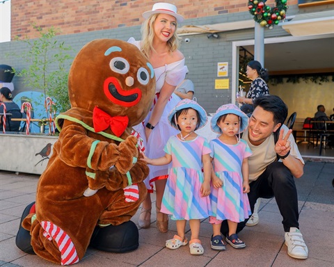 2024 Canley Heights Children's Christmas - Gingerbread mascot posing with little girls and their dad.