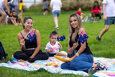 Family-sitting-on-grass-at-Adams-Park-waving-Australia-flags.jpg