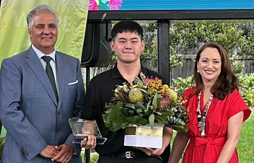 Portrait of Tevin Luu holding Australia Day Award with the Mayor.