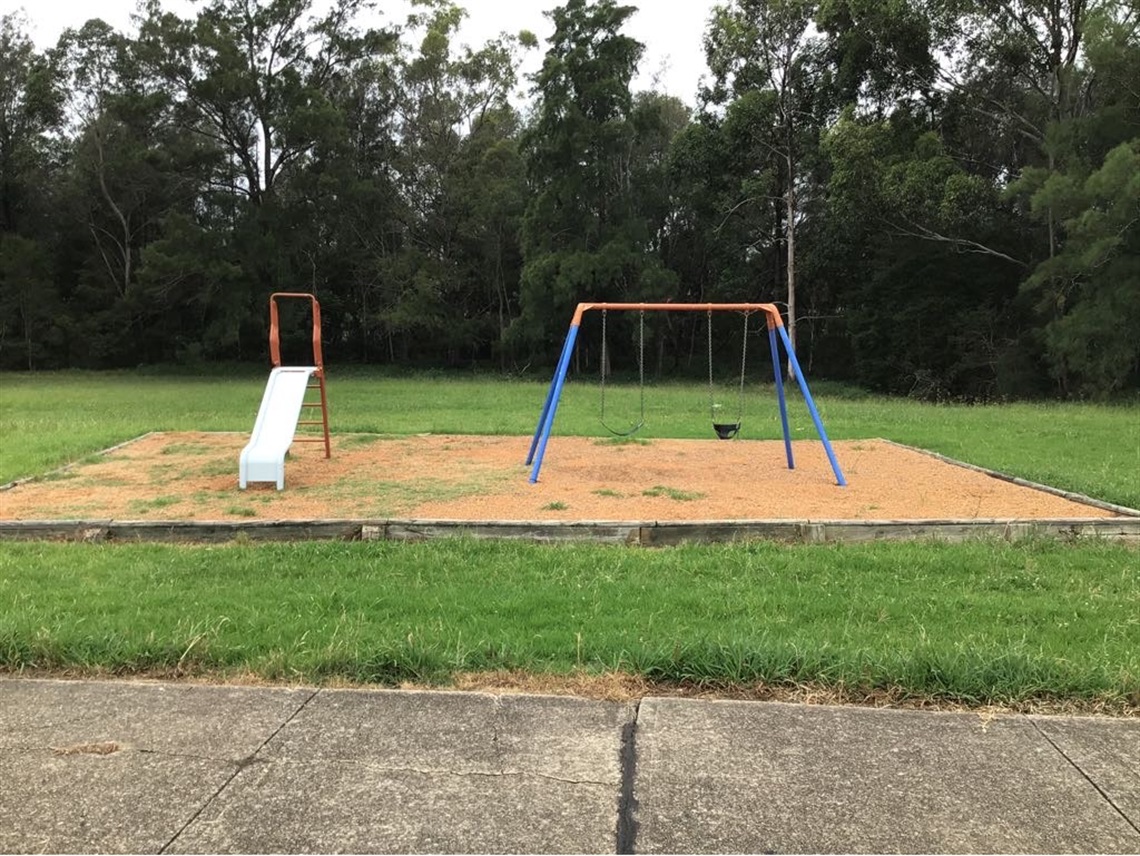 Playground including a small slide and swings at Choma park.