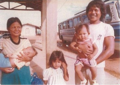 Old photograph of young Cambodian couple with three young children at a train station