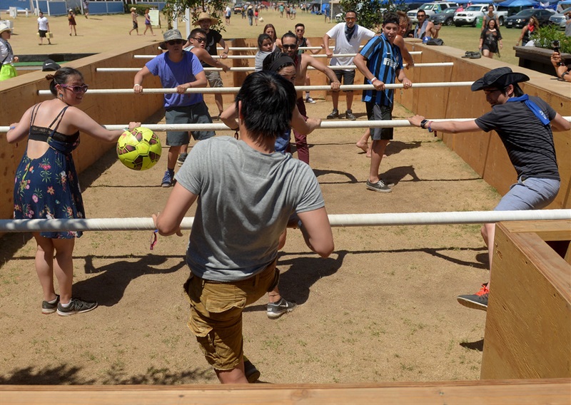 Group of friends kicking a ball around, playing human foosball 