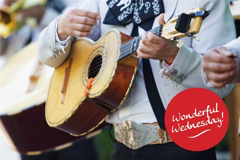 Close up of man playing a guitar in a mariachi band