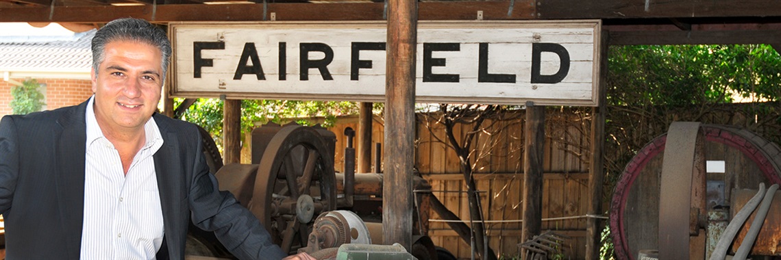 Mayor Frank Carbone standing in front of a sign saying FAIRFIELD at Fairfield City Museum and Gallery