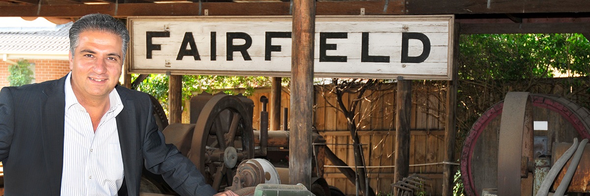 Portrait of Mayor Frank Carbone at the Fairfield City Museum Gallery & Museum posing in front of Fairfield sign